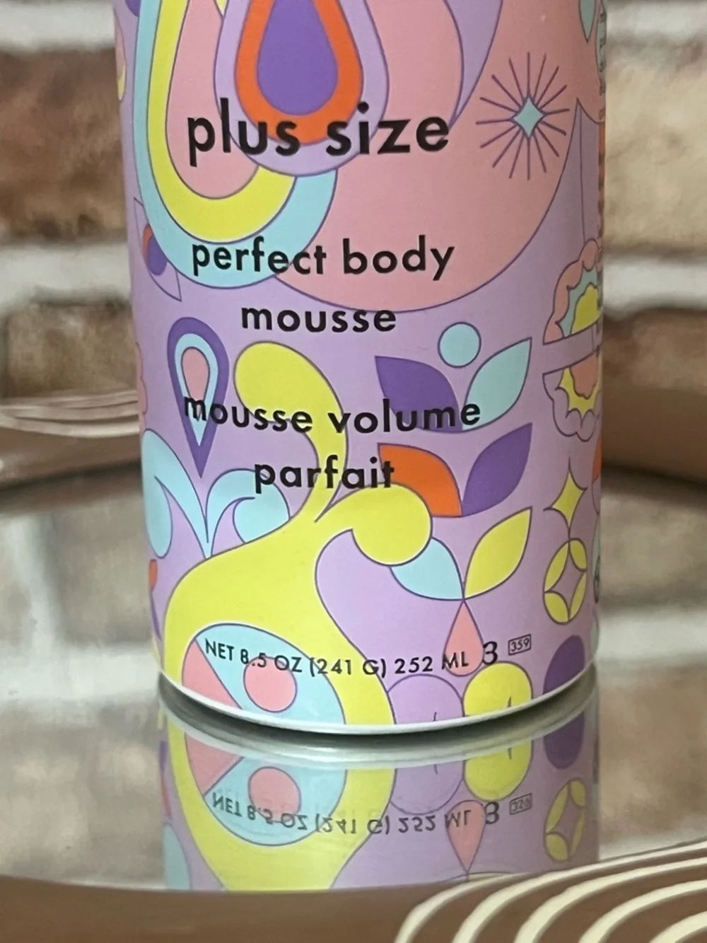 amika body mousse in pink, purple & yellow patterned bottle